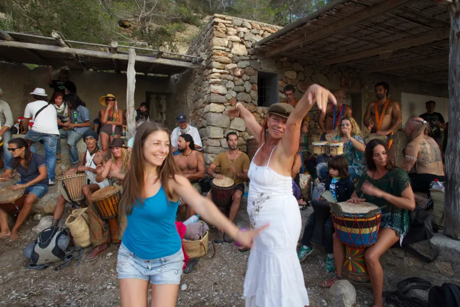 Women dance barefoot among drummers at an open-air gathering