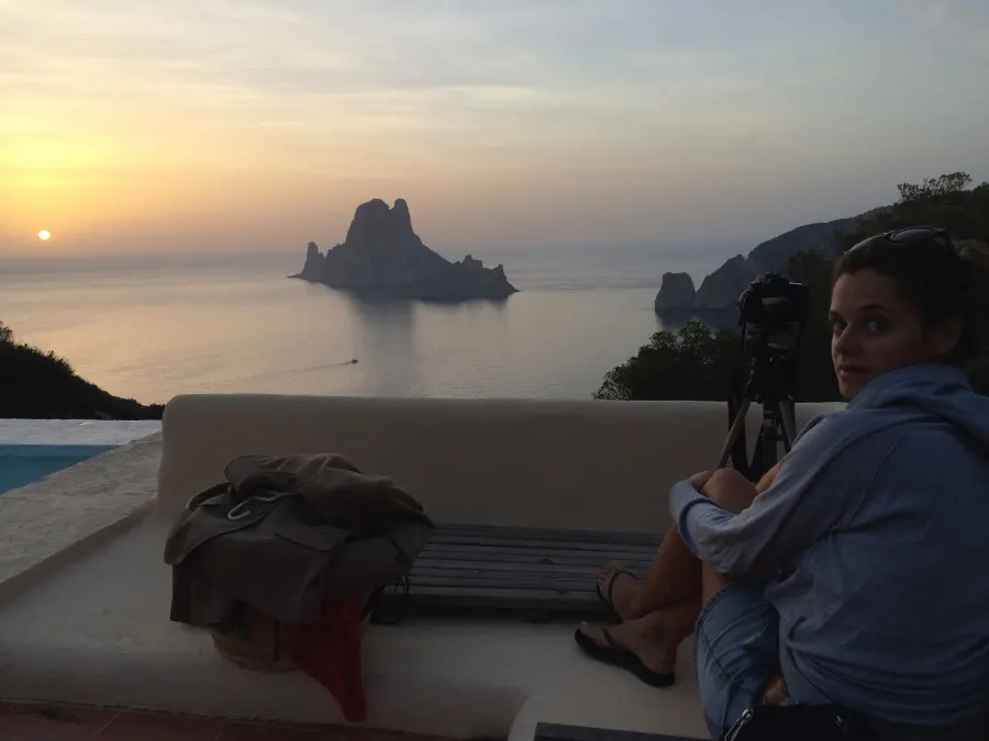 Sunset over the sea with Es Vedrà, a woman on a terrace